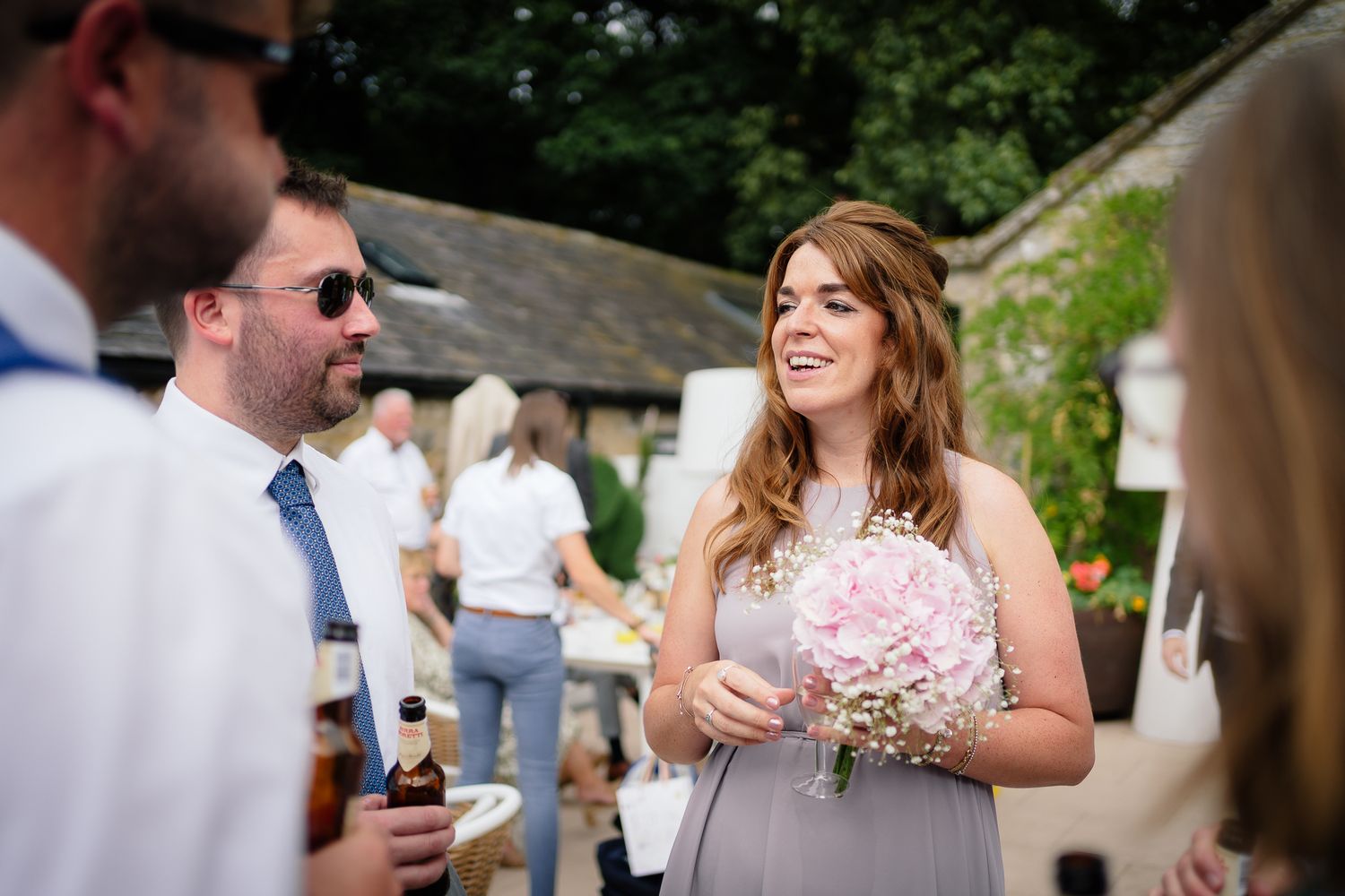Guests mingle and celebrate during sunny outdoor wedding reception. Woodhill Hall.