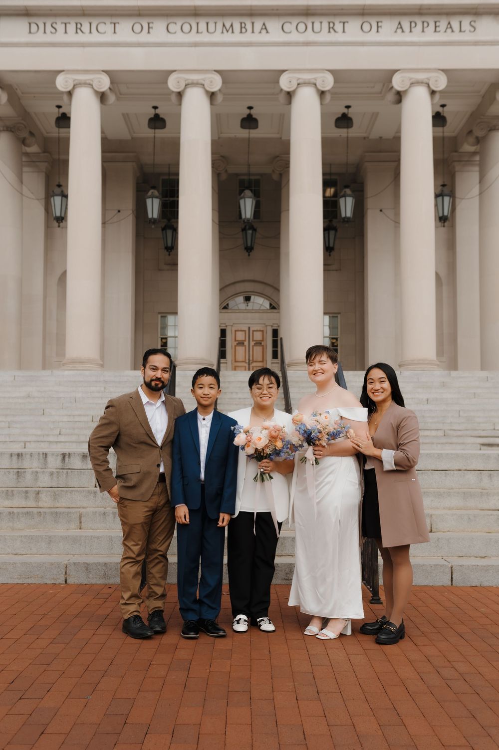 Wedding party gathered on brick steps of District of Columbia Court of Appeals building.