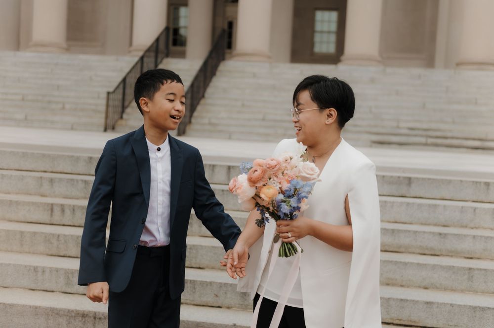 Couple sharing a moment on stone steps during wedding celebration.