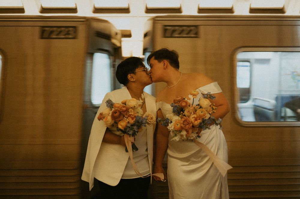 Couple embracing in warm-lit indoor venue with elegant architectural details.
