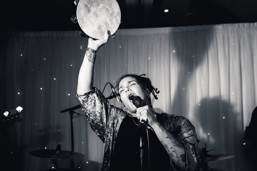 Black and white photo series of someone holding a balloon in front of curtains with dramatic lighting effects.