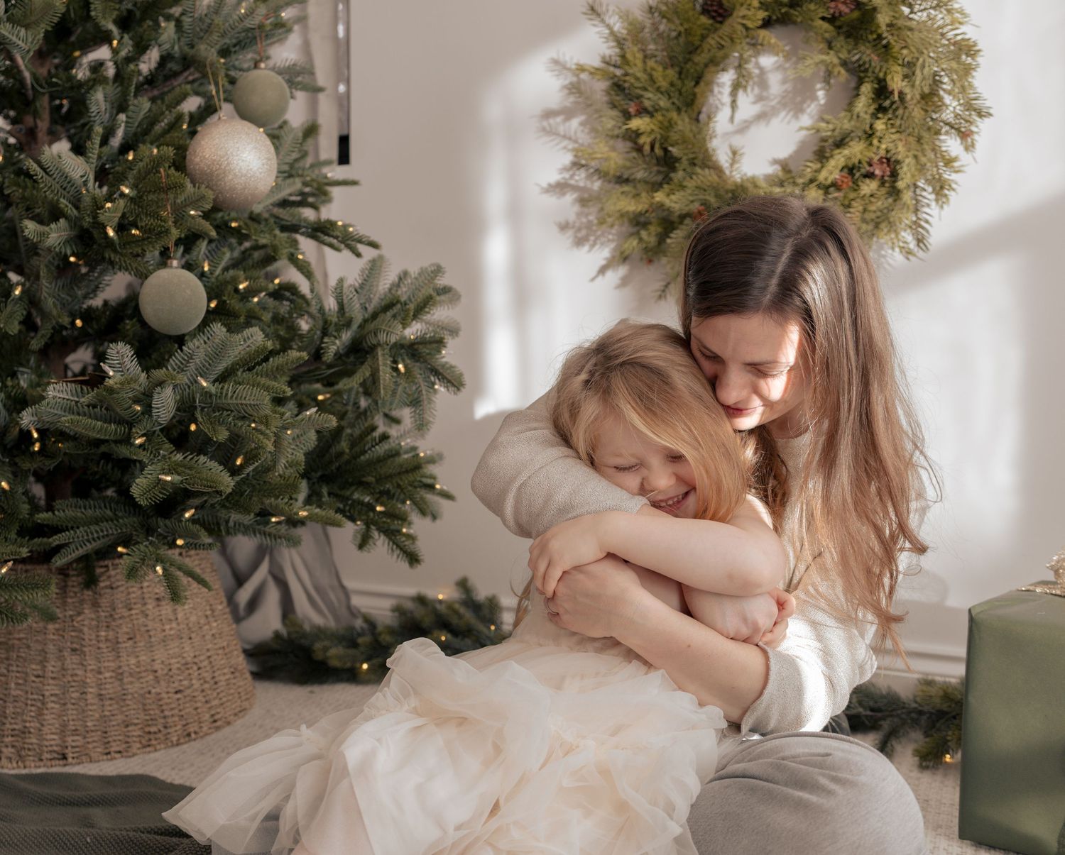Festive holiday portraits with decorated Christmas tree and wreath in background. Photography in Buckinghamshire.