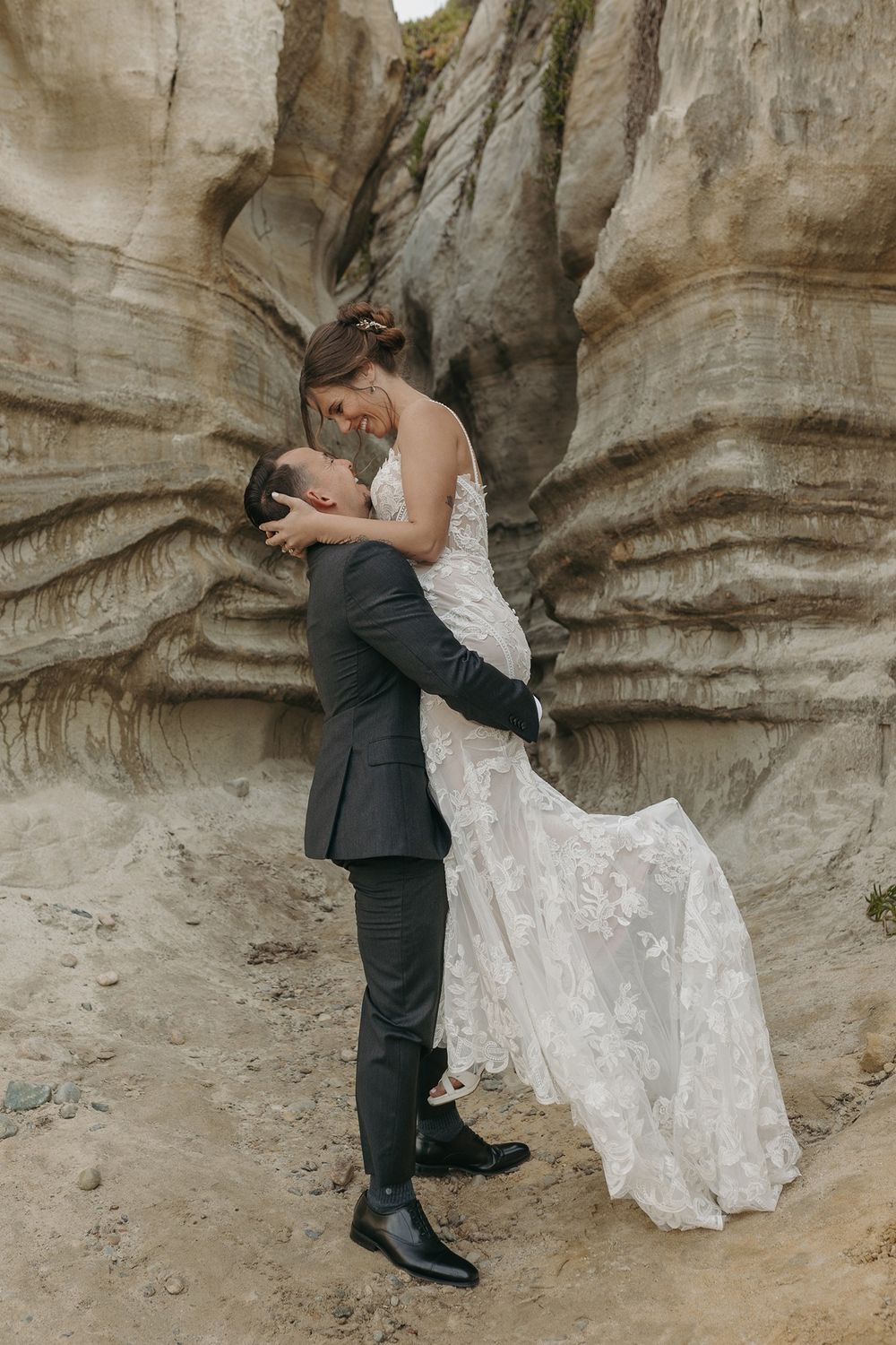 Wedding couple poses intimately against textured canyon walls at Calafia Beach Park in San Clemente.