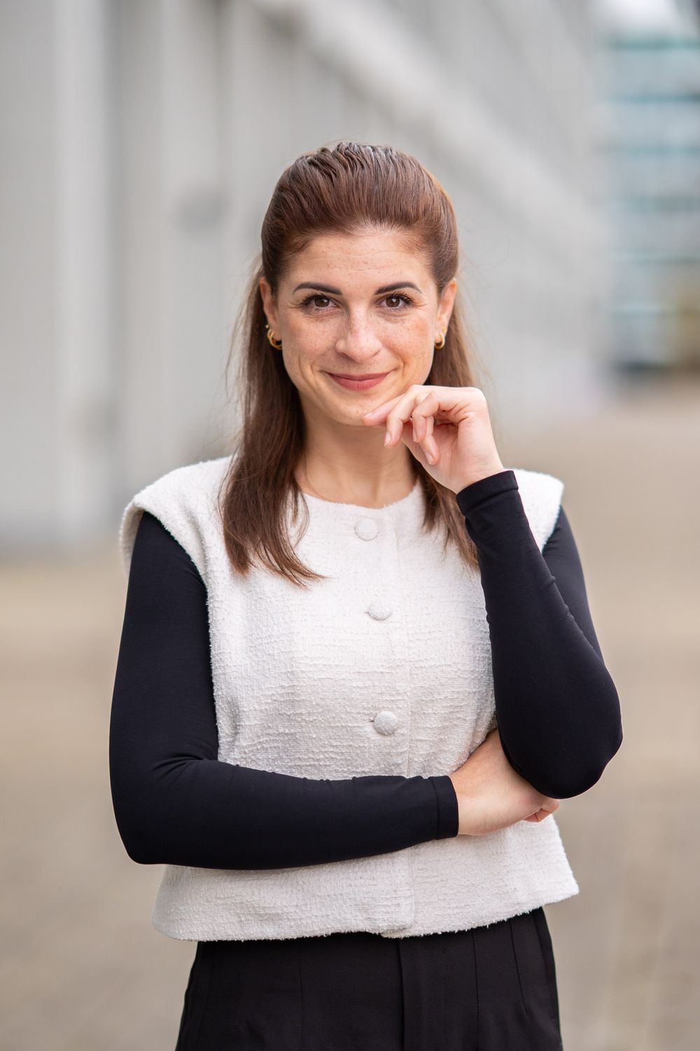 Woman wearing black and white color block sweater poses in professional headshot series.