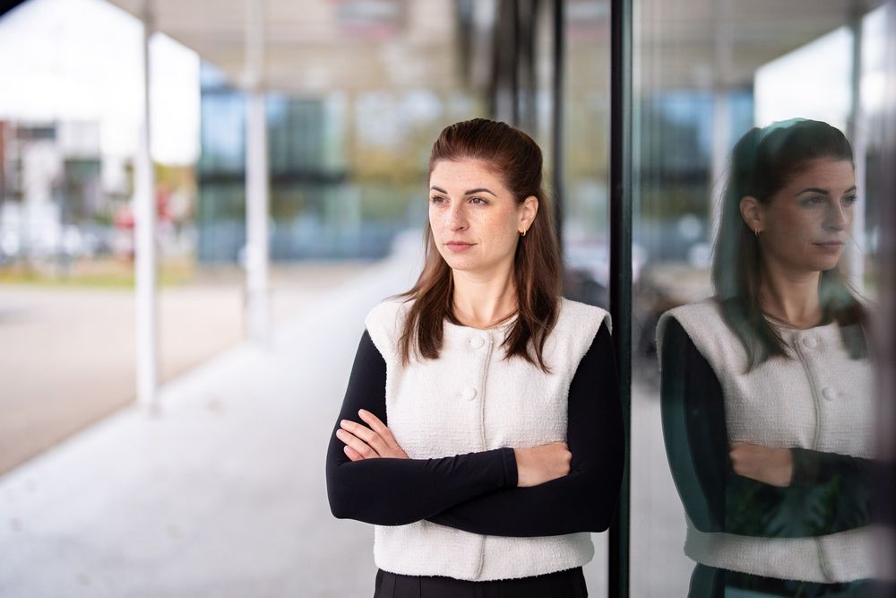 A professional woman in business attire poses in various positions against a white modern office background.