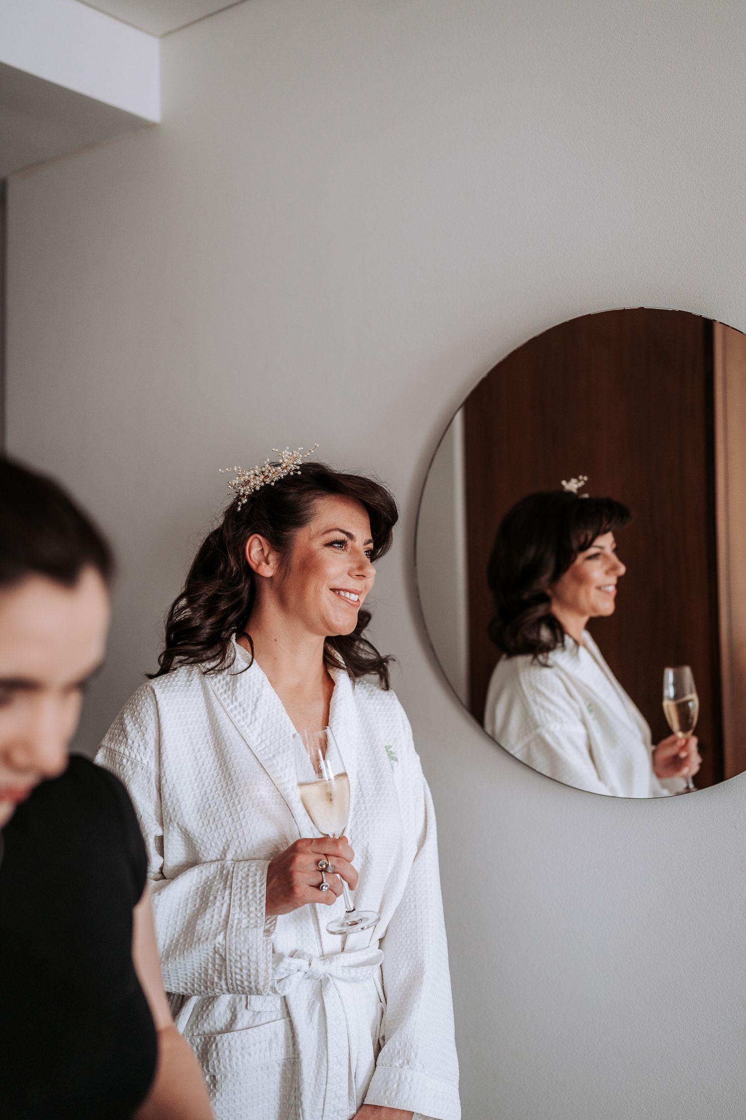 A series of candid moments showing someone in a white robe getting ready while holding champagne.