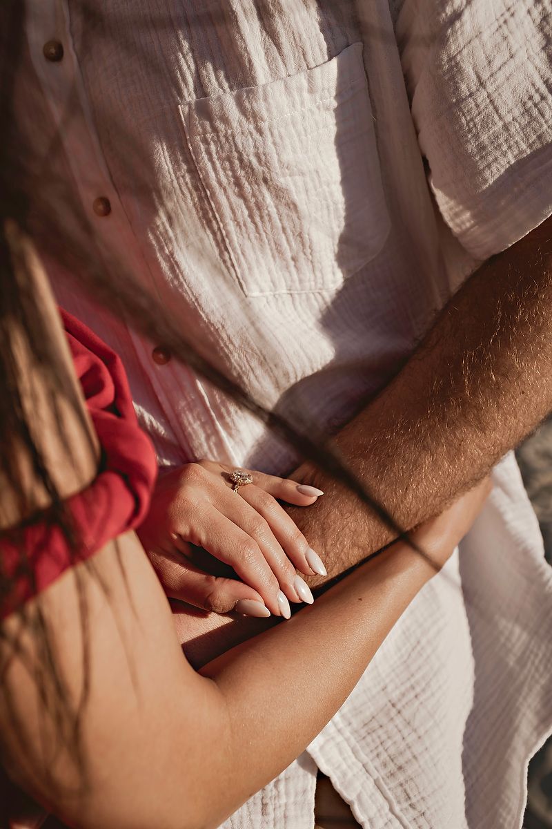 Close-up sequence showing hands gently pressing and massaging bare skin against white fabric background.