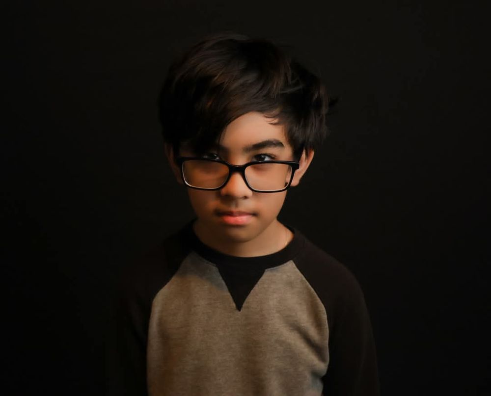 Dramatic low-key lighting portrait against dark background.