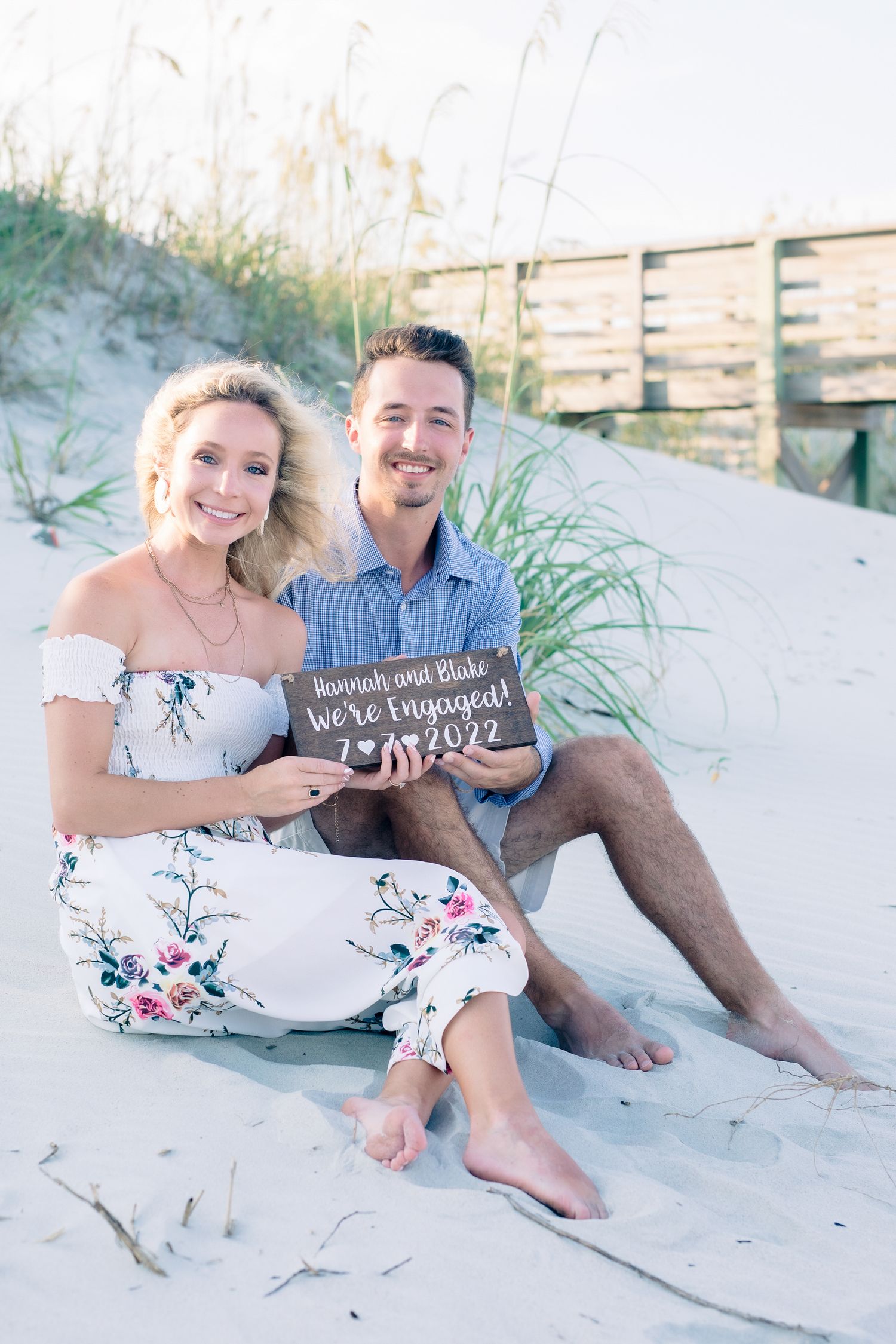 Newly engaged couple laughing and embracing on scenic beach, Windsor Ontario, captured by Tasha Cannaday.