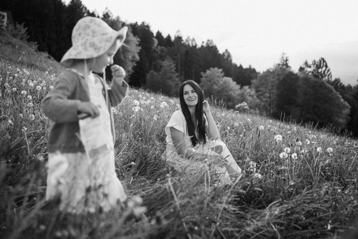 A black and white photograph of a family moment in a wildflower field.