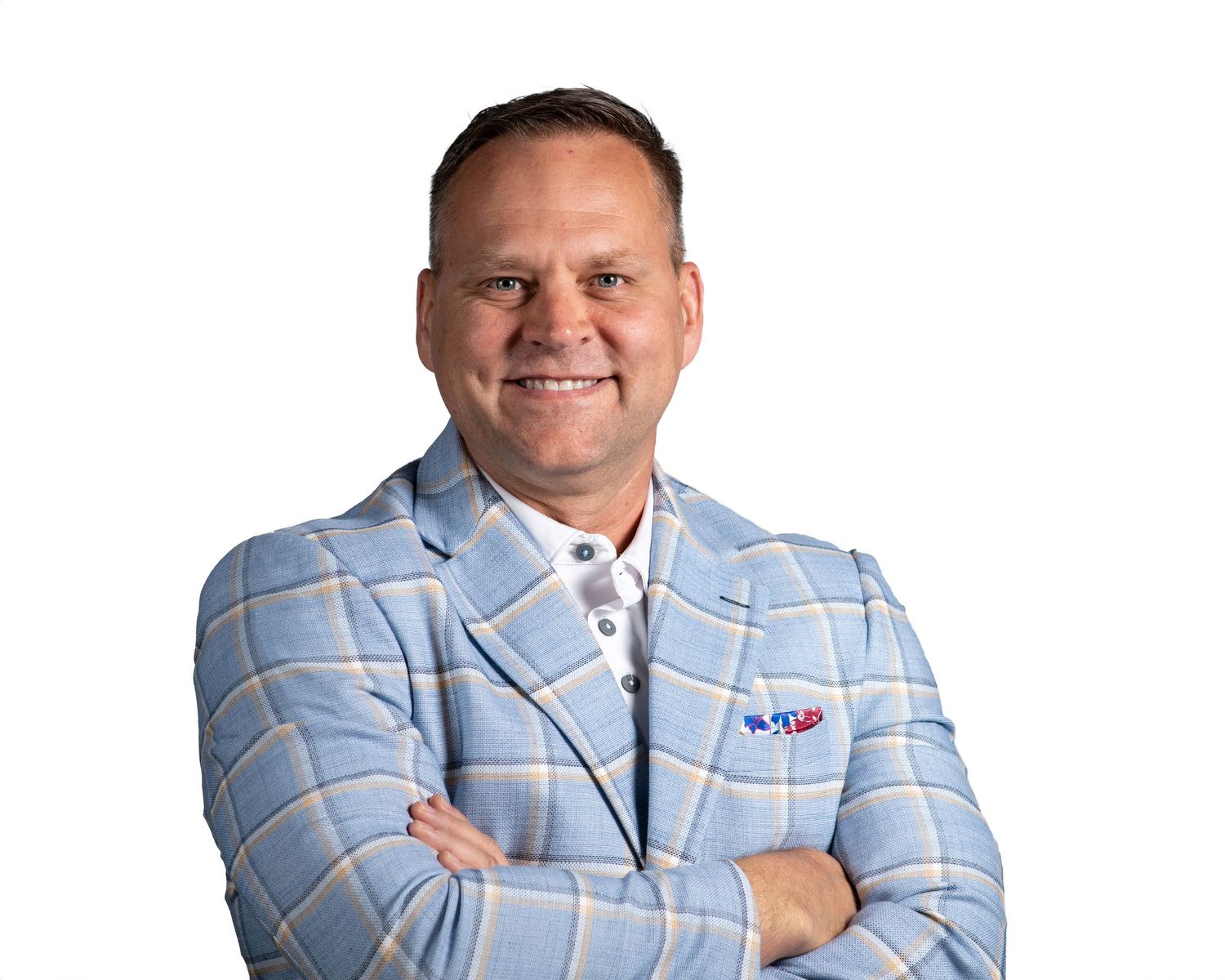 Professional headshot of someone wearing a light blue plaid blazer with arms crossed and a friendly smile.