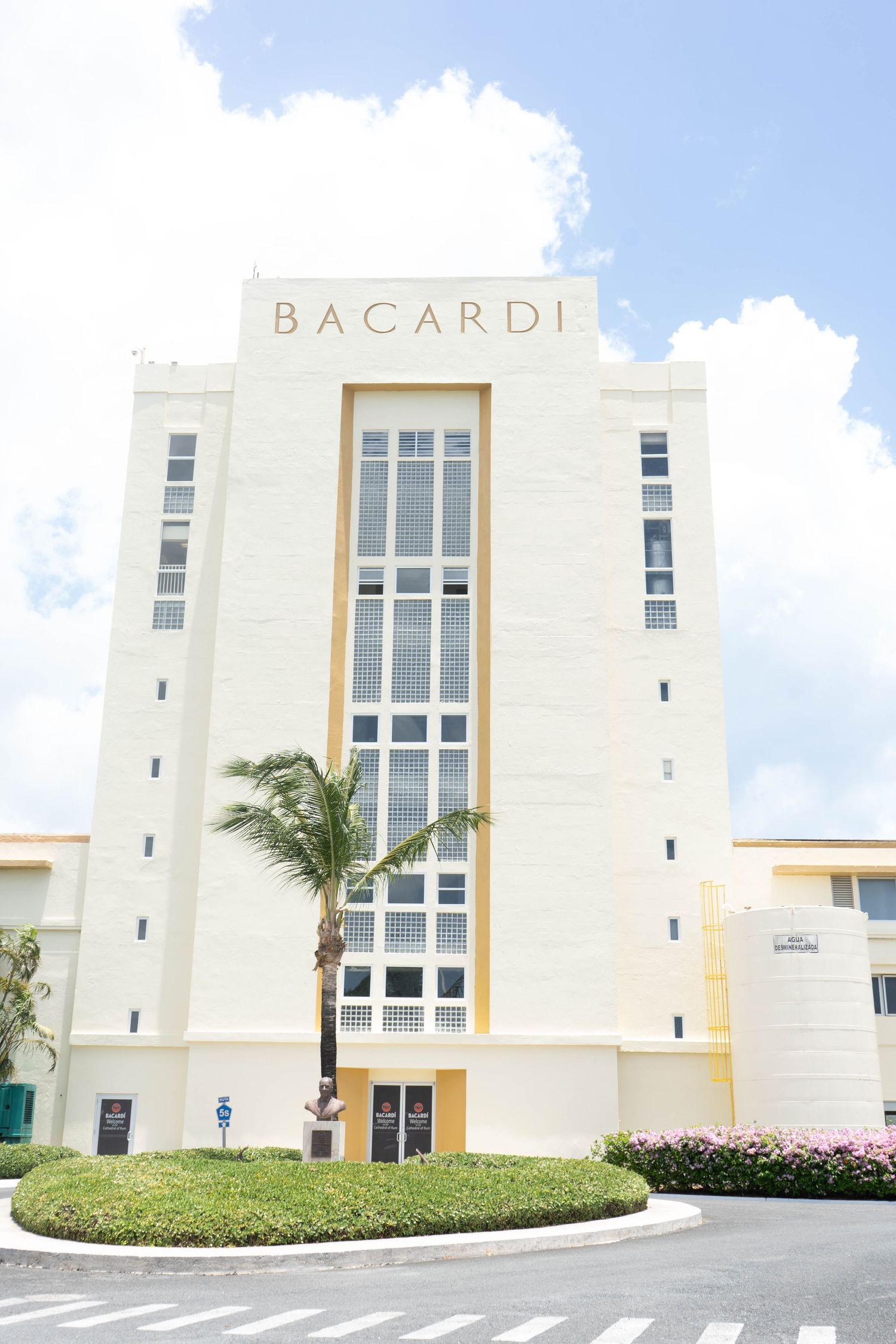 Art Deco Bacardi headquarters building with white facade, tall windows, and tropical landscaping in Miami.
