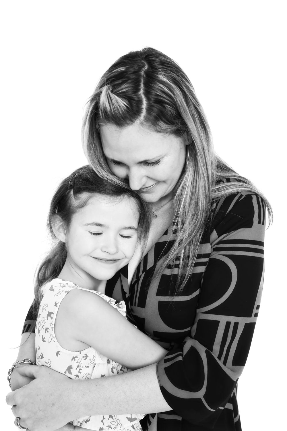 A tender black and white photo of a parent and child embracing in a loving hug.