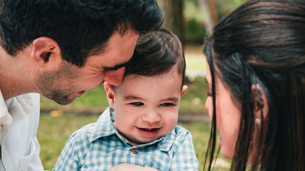 Family enjoys a playful moment together in a lush outdoor setting during a lifestyle photo session.