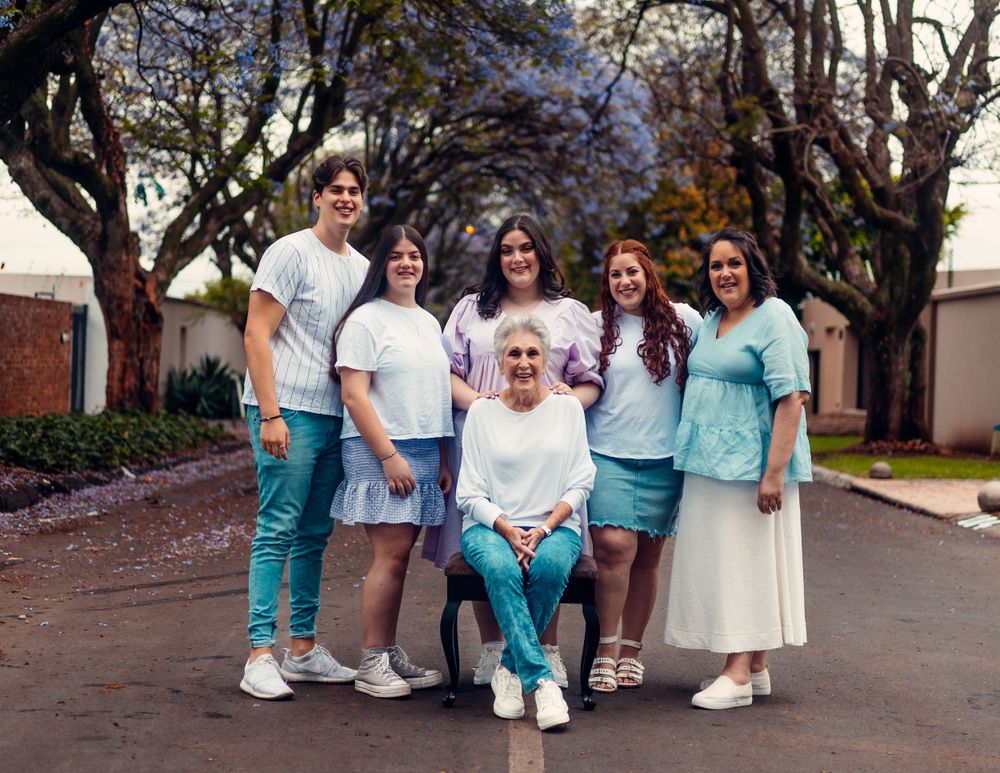 Group of people walking together outdoors wearing coordinated white and turquoise outfits.