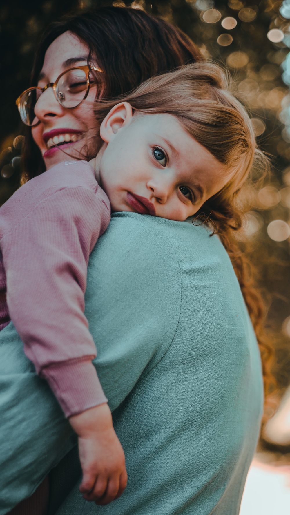 Tender embrace captured in warm golden light with bokeh background.