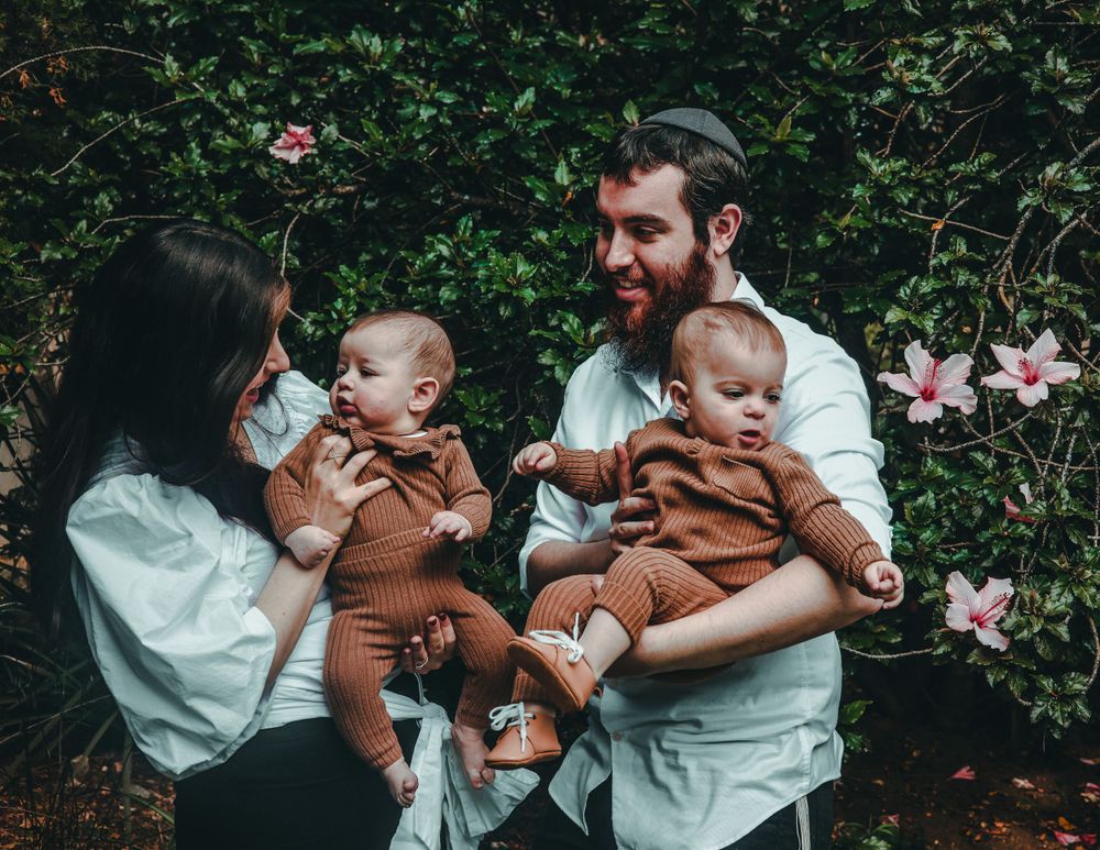Sweet candid family portrait session captured in a garden setting with natural lighting and soft moments.