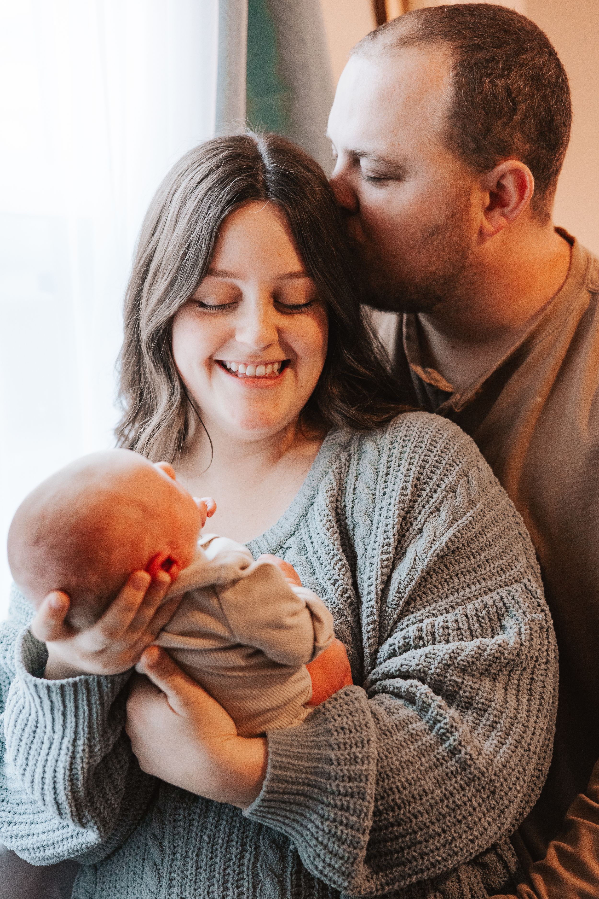 Loving family moment captured in sequence showing parents cuddling with their newborn baby.