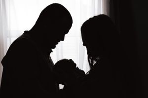 Artistic silhouette series capturing intimate family moments against bright window light.
