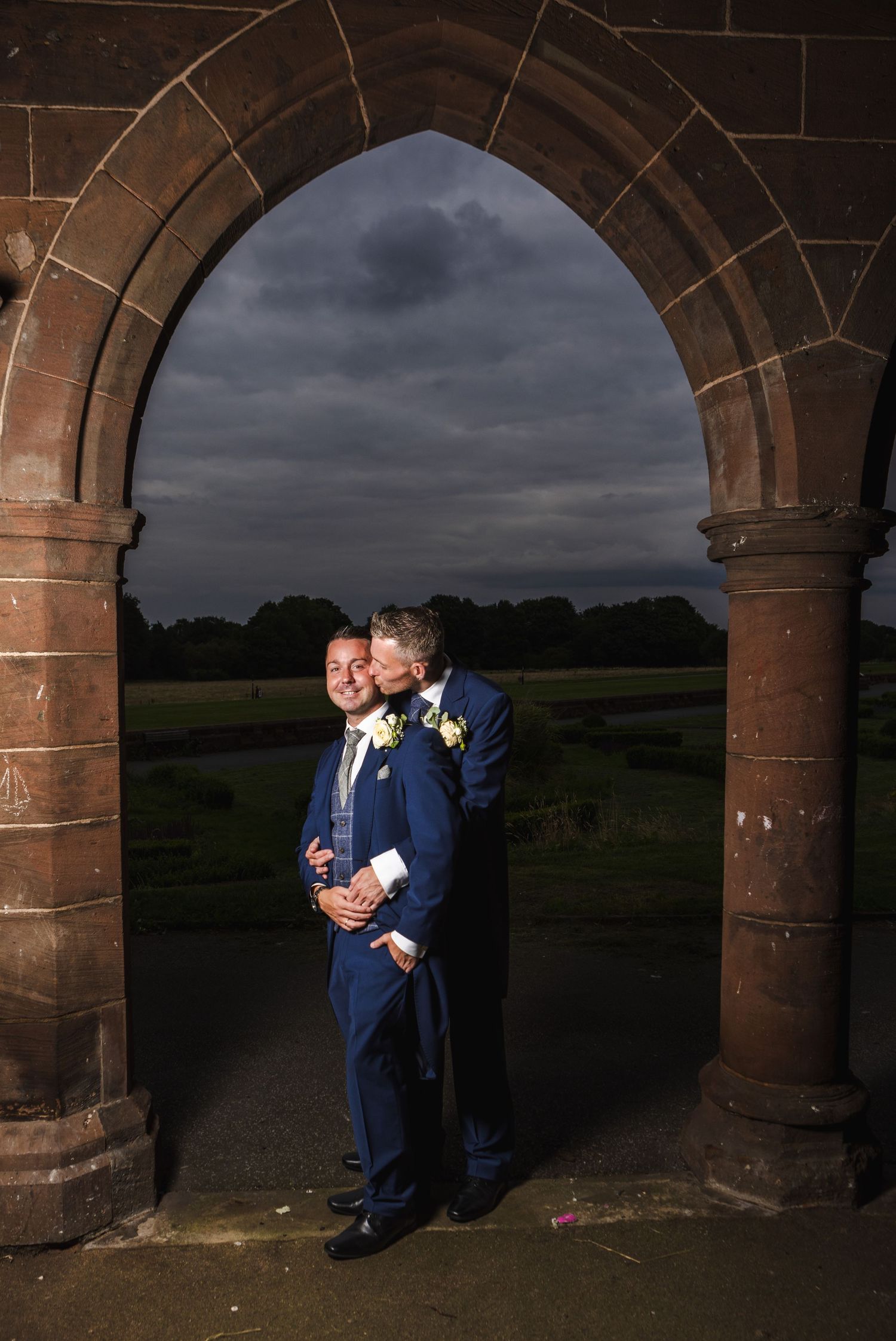 Dramatic portrait sequence under stone archways at dusk.