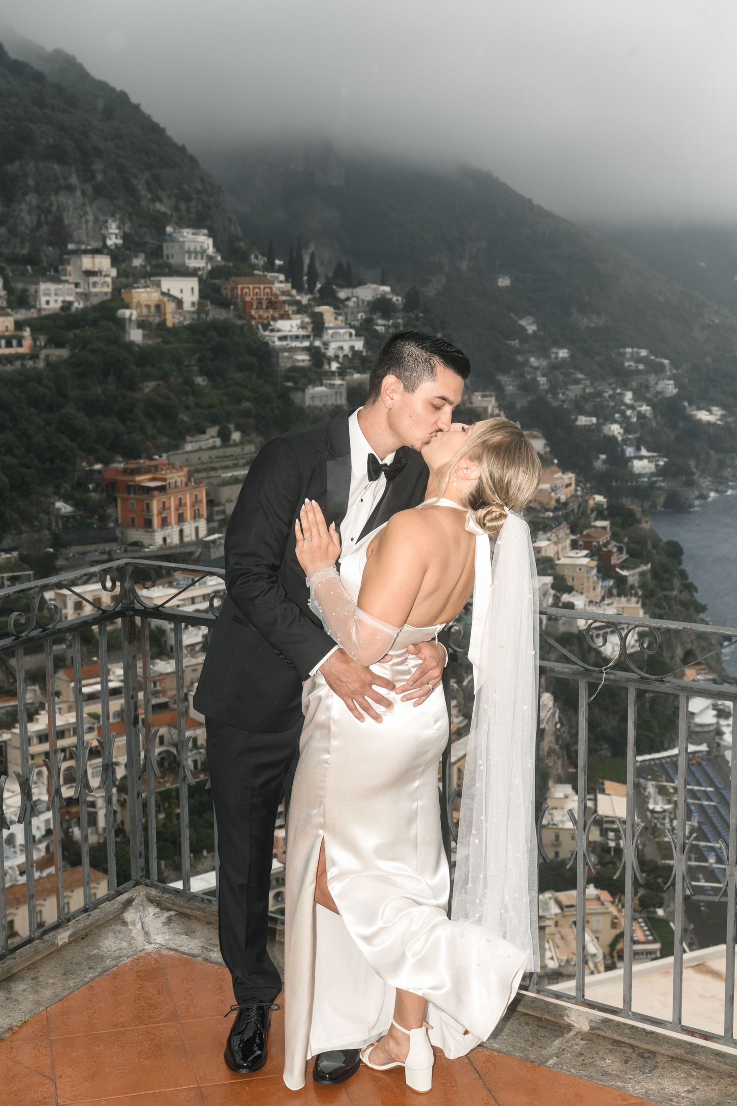 Romantic wedding portrait overlooking scenic Positano coastline in Italy.