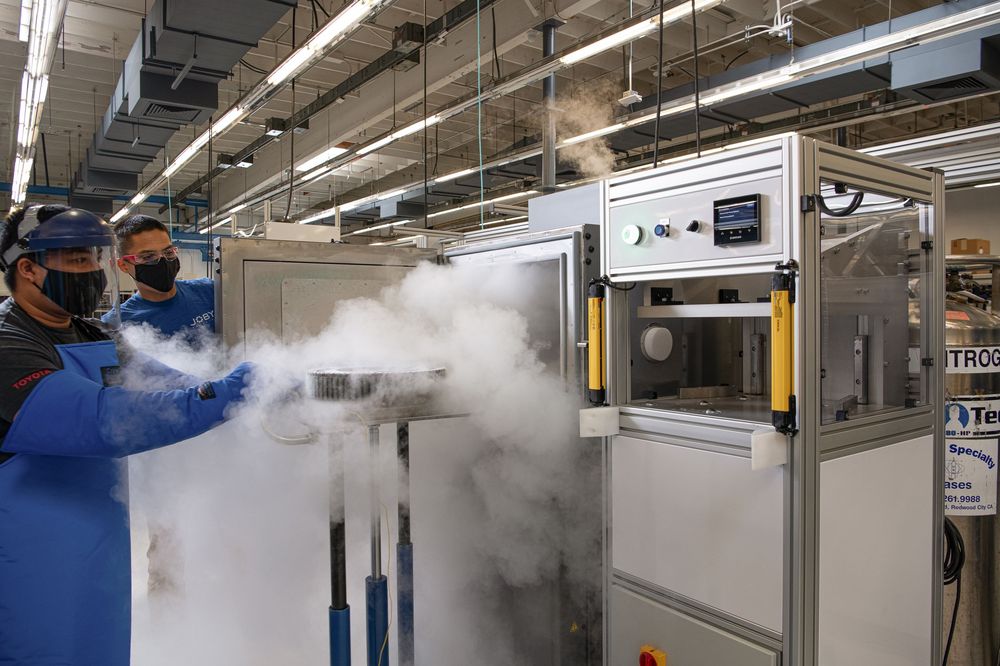 Industrial manufacturing facility showing equipment and machinery with steam or vapor visible in the workspace.