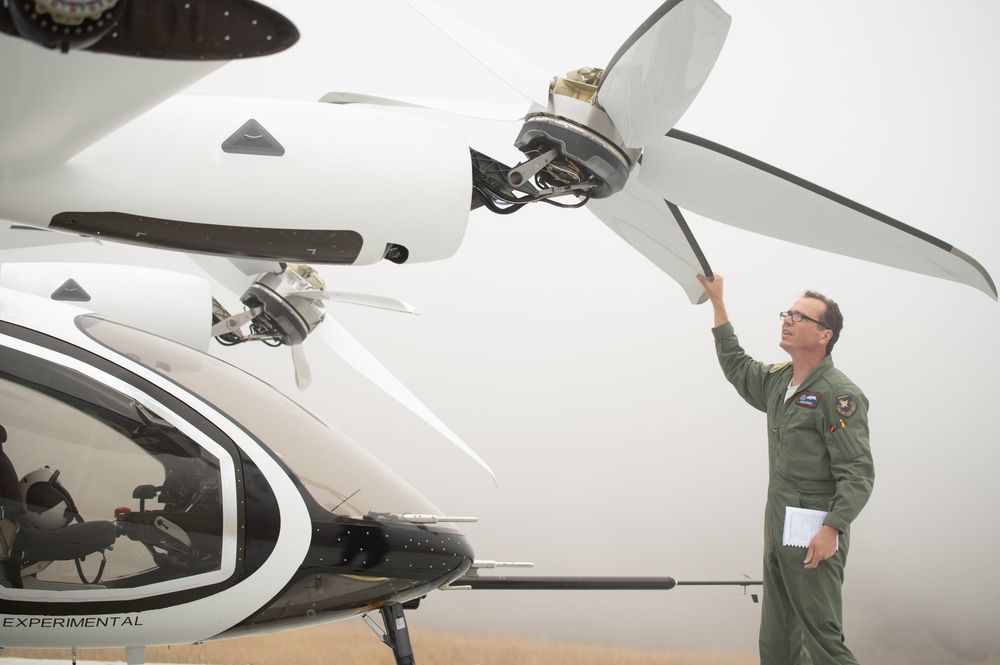 Technician inspecting aircraft components and equipment in a hangar setting.