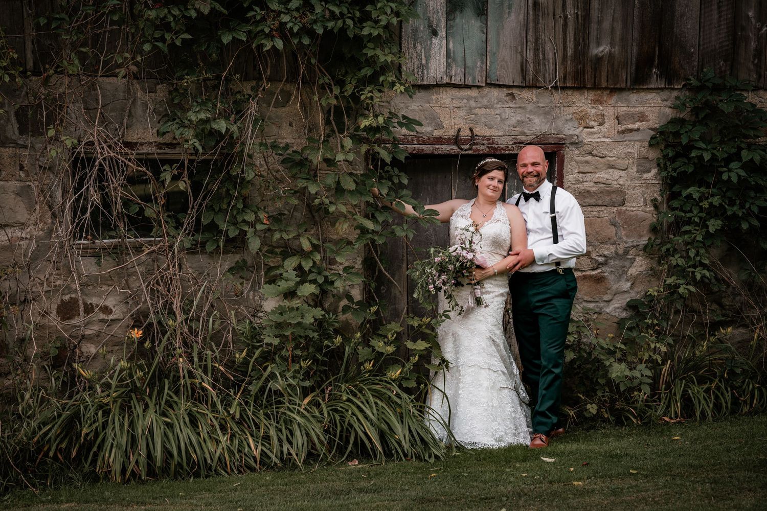 A portrait of a bride and groom posing near an old barn in Terra Cotta, Ontario.