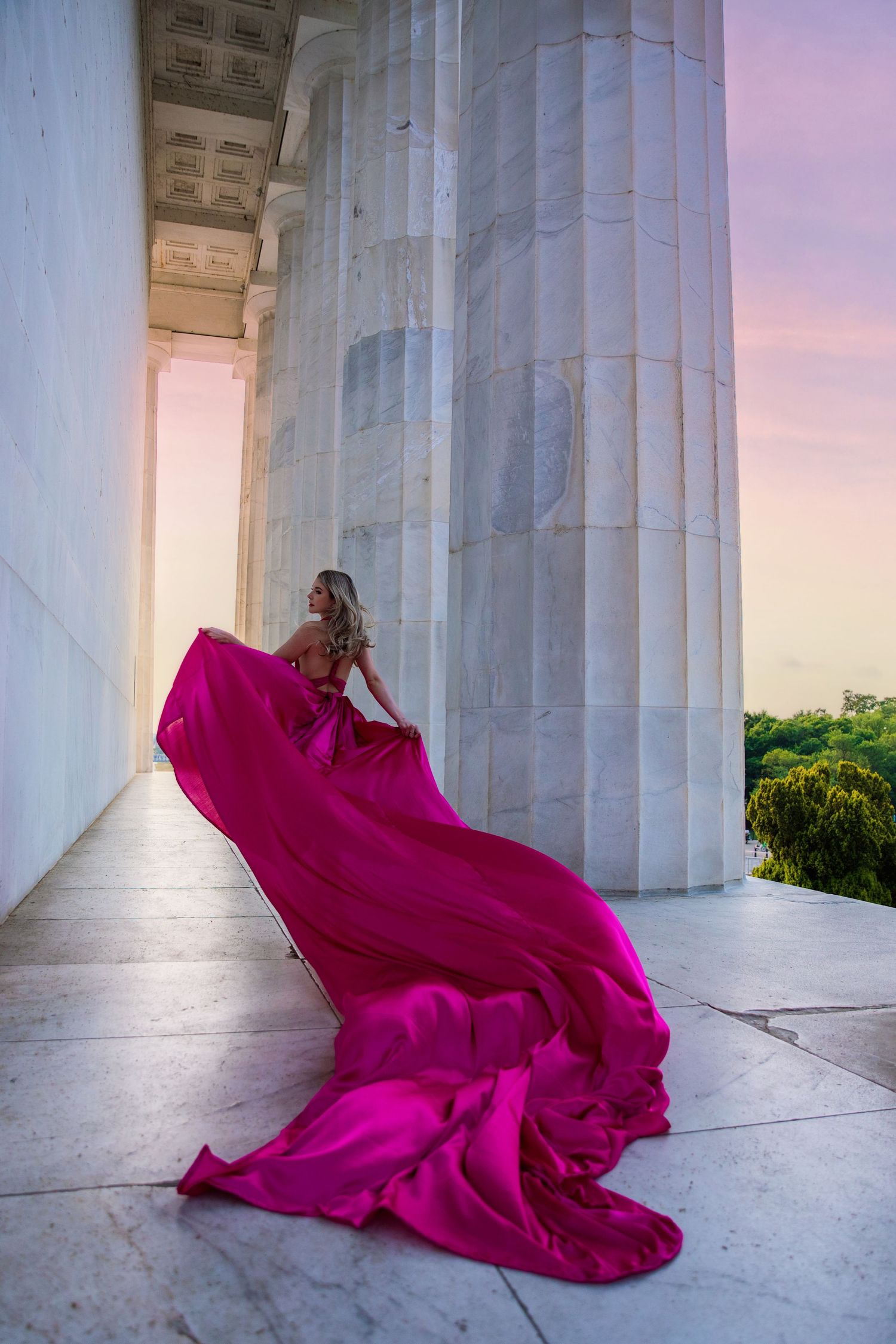 A flowing magenta dress billows dramatically between white marble columns at sunset. My Flying Dress Washington DC