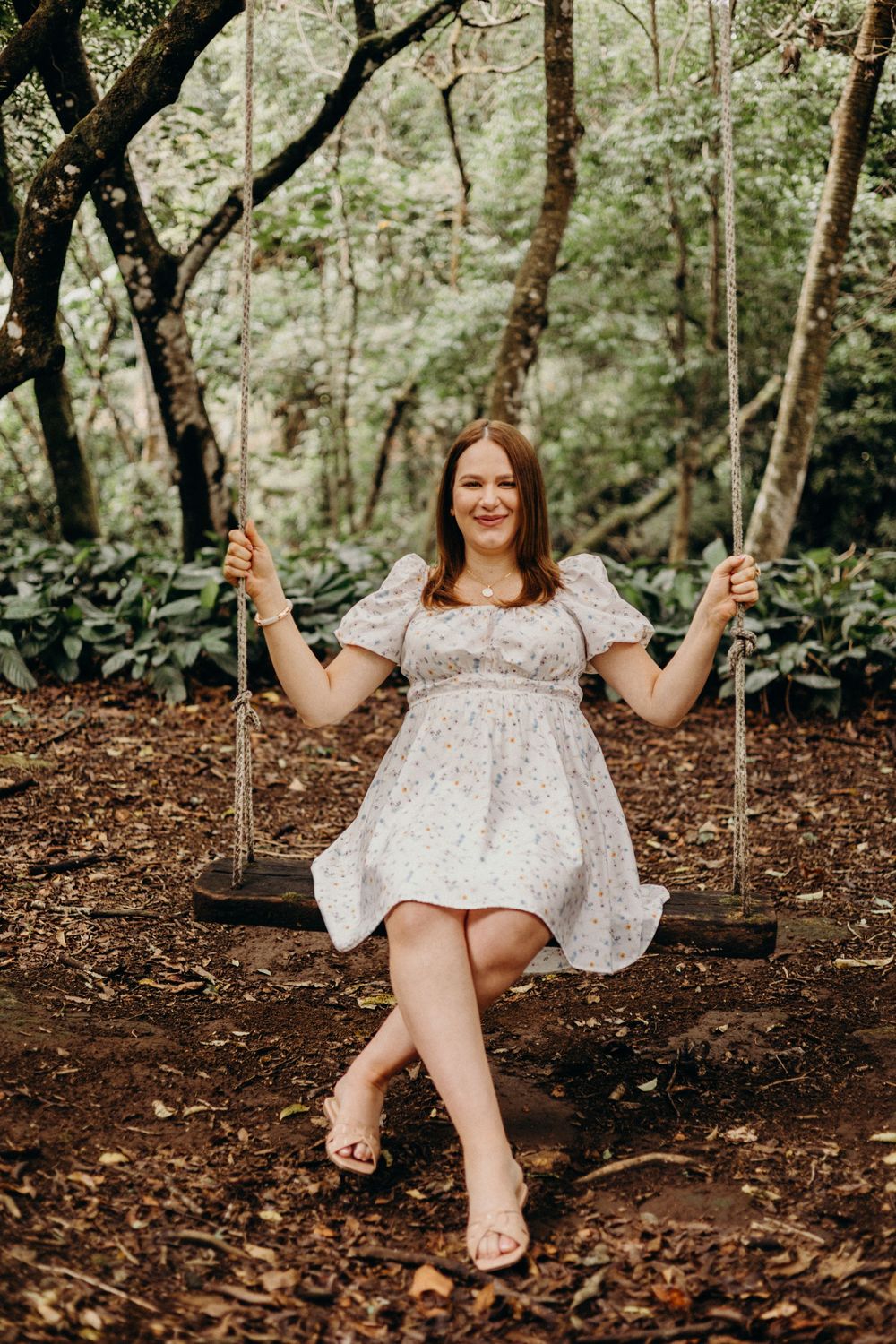 A joyful moment captured on a rustic tree swing in a wooded garden setting.