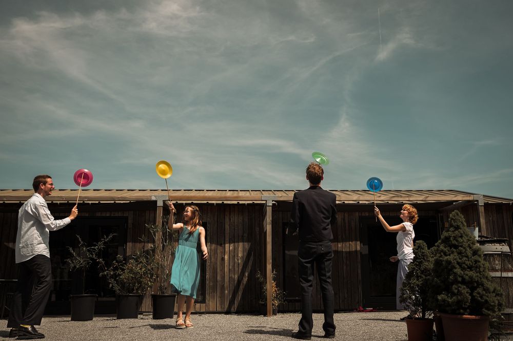 A series of wedding party members holding colorful balloons against a rustic wooden barn backdrop.