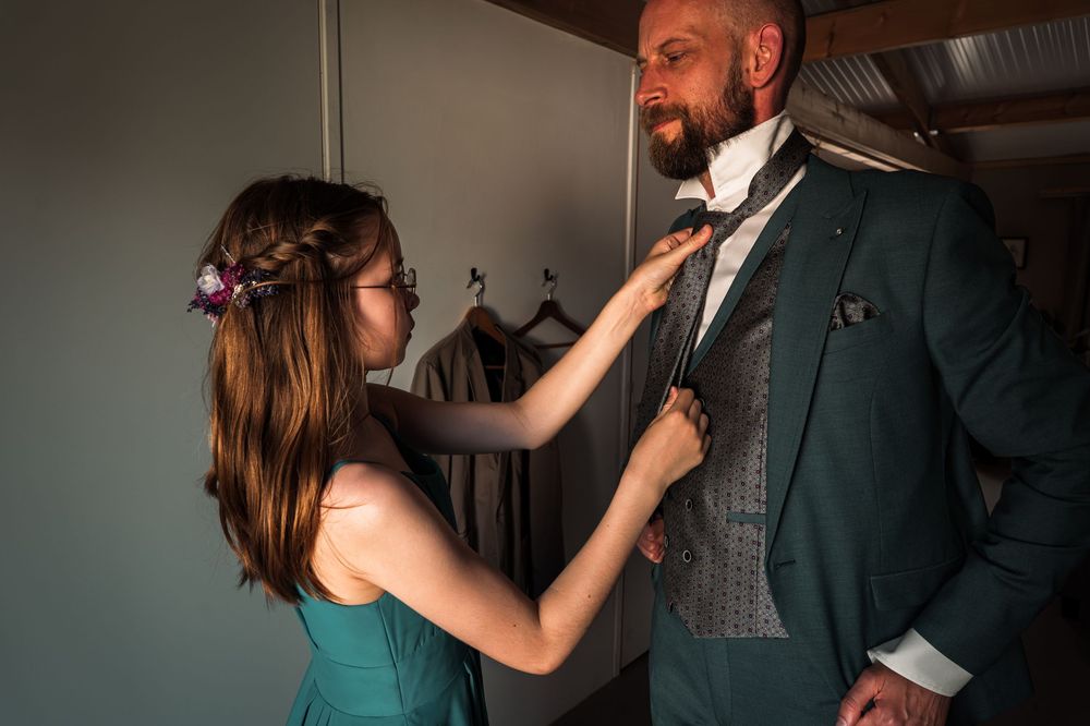A couple dances together in an intimate indoor setting with warm lighting.
