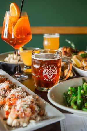 Plated dishes with beer pairings featuring green vegetables and garnished entrees on white plates.