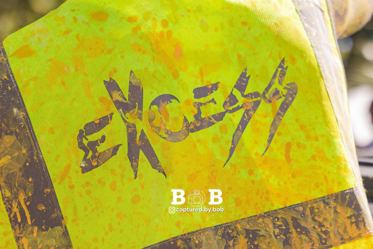The Excess Jouvert troupe costume features the “Excess” logo, covered in paint during Carnival celebrations, at Sugar Mas 54 in St. Kitts.