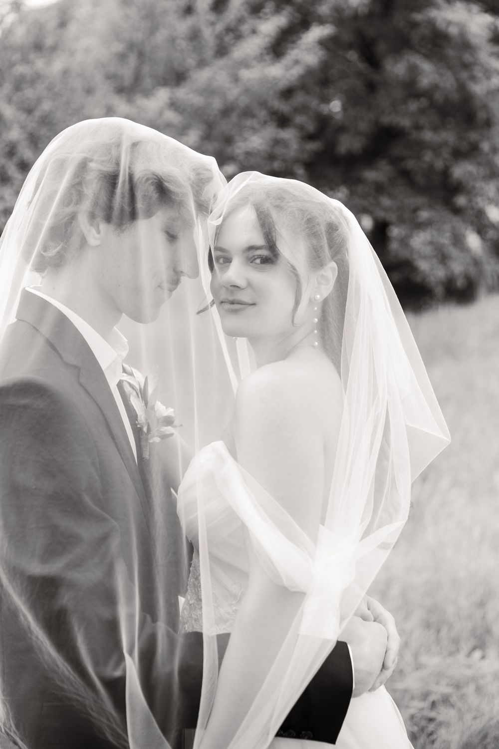 Ethereal black and white portrait sequence of a bride beneath a flowing white veil.