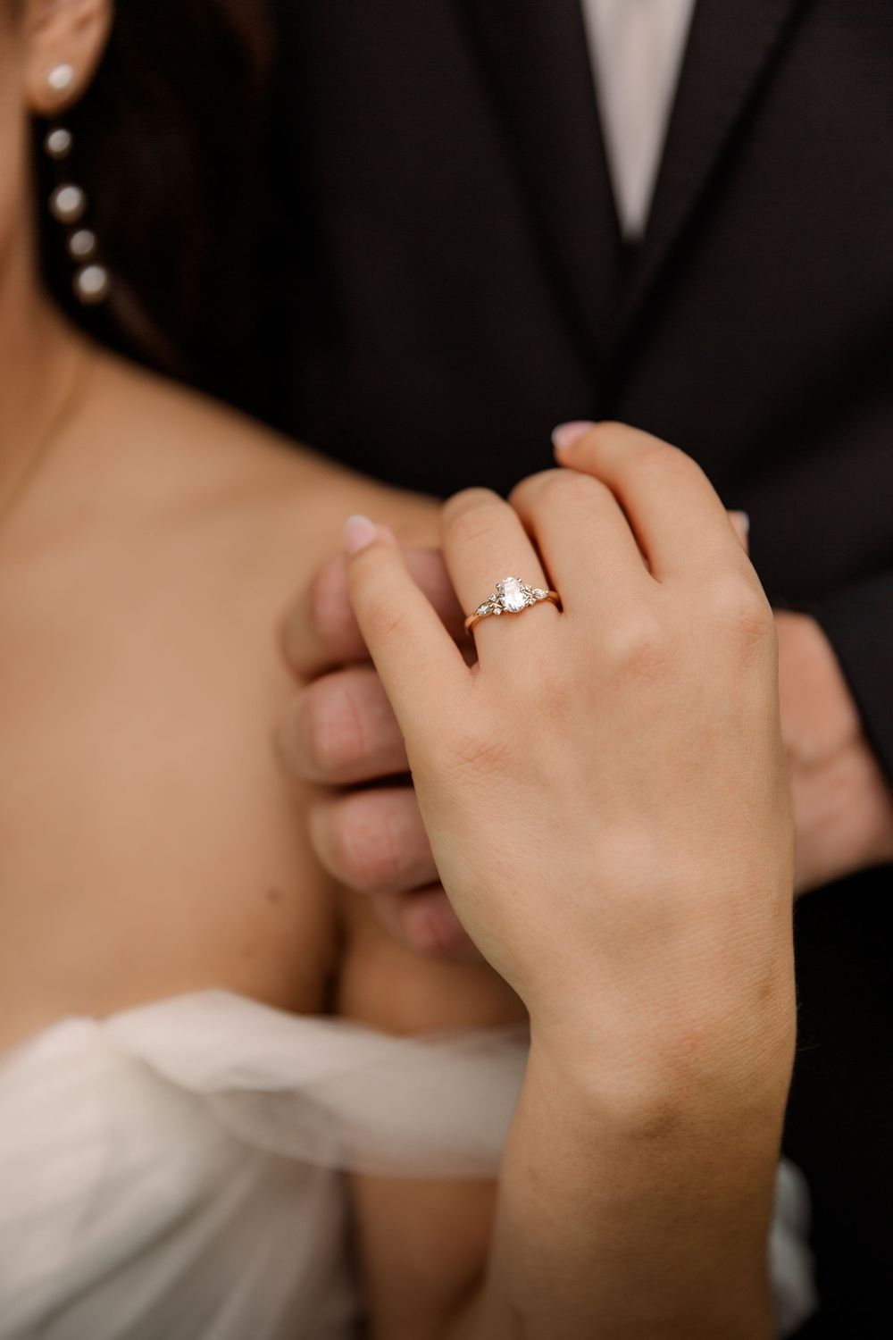 Close-up shot of hands with an engagement ring in romantic lighting.