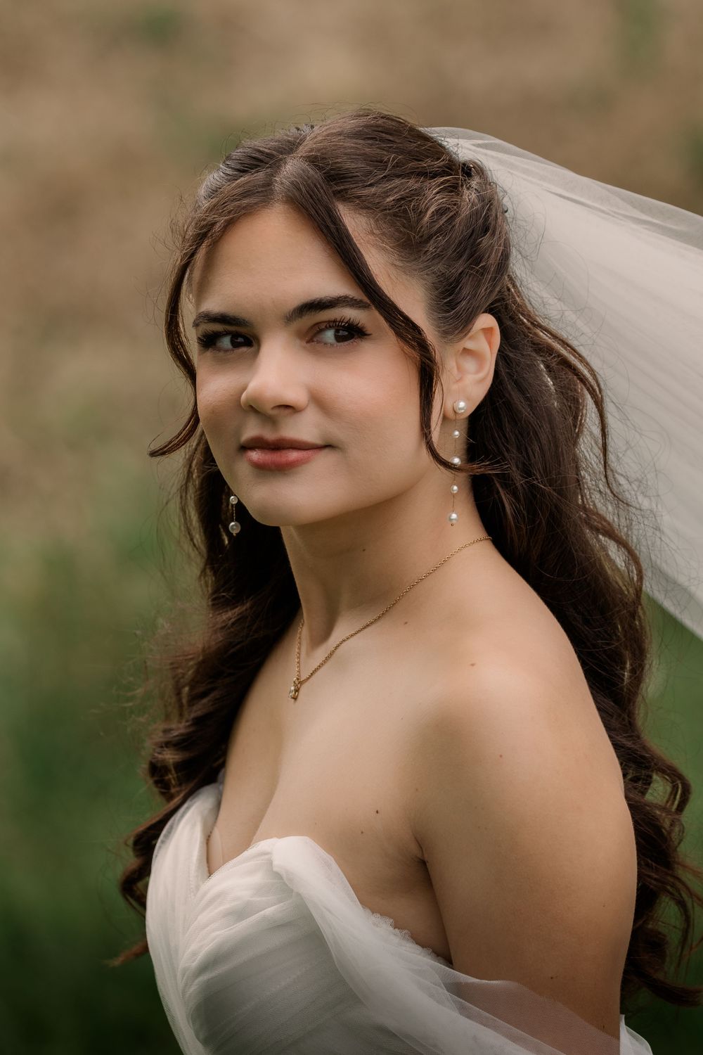 Close-up portrait of a bride wearing a sweetheart neckline dress and delicate veil.