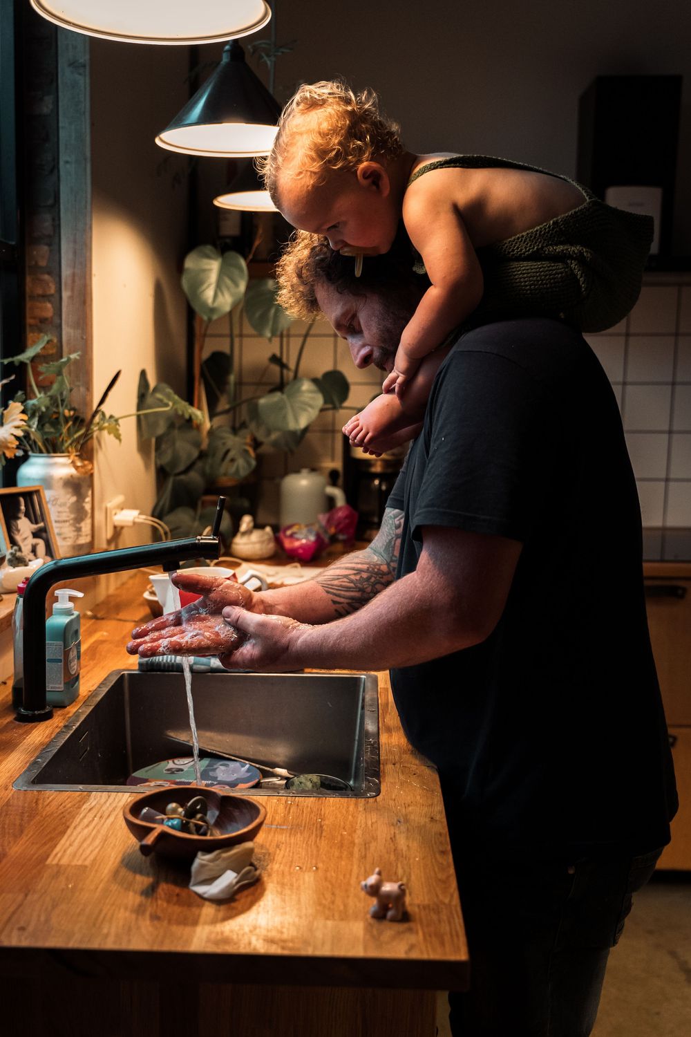 Two people prepare food together in a warmly lit kitchen with modern fixtures.