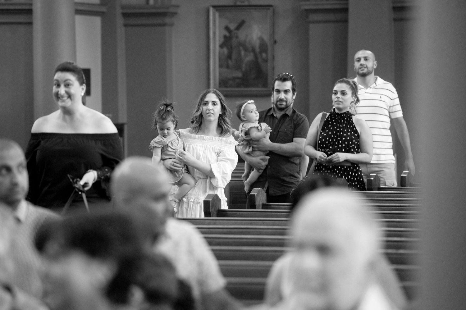 Congregation gathers in traditional church pews during religious ceremony.