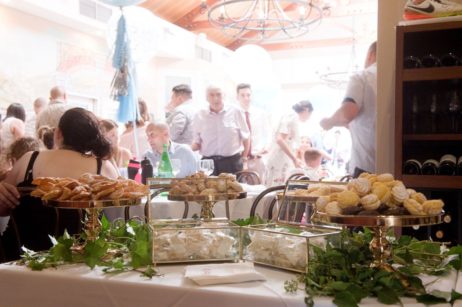 Elegant buffet table with assorted pastries and appetizers at a busy catered social event.