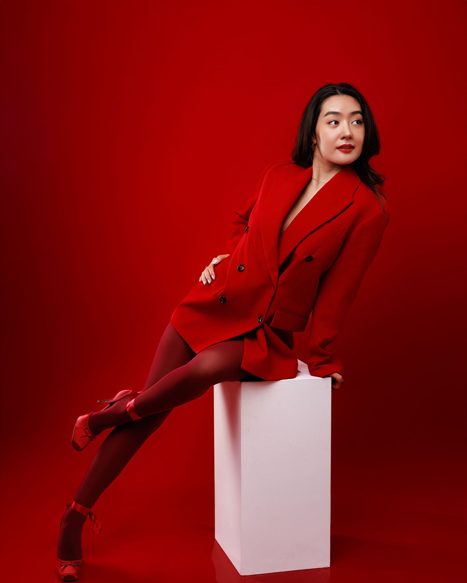 A woman in black attire strikes dynamic poses against a white backdrop in a fashion photo series.