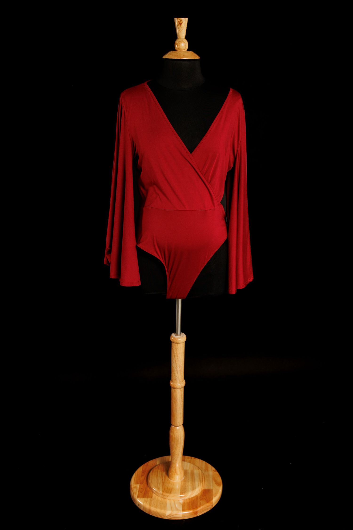 Deep red long sleeve maternity bodysuit with wrap neckline on mannequin.
