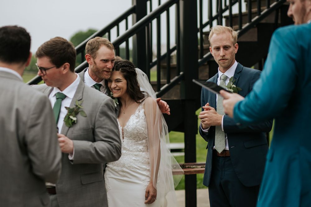 Wedding celebration guests mingling and taking photos at an outdoor venue.