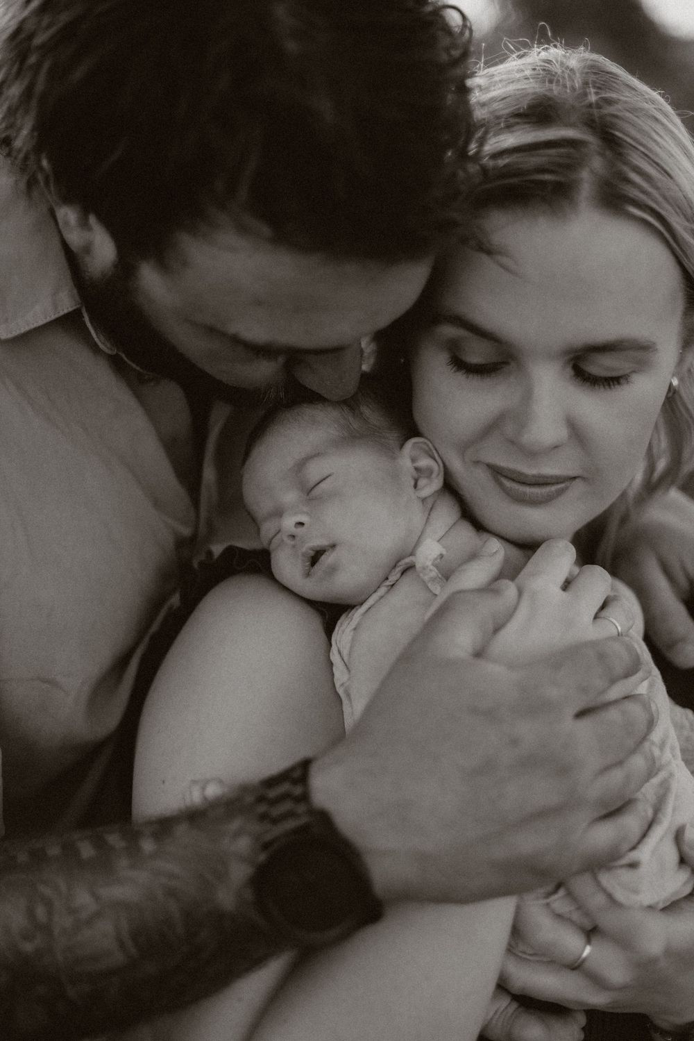 A series of black and white intimate photographs showing tender moments between parent and child.
