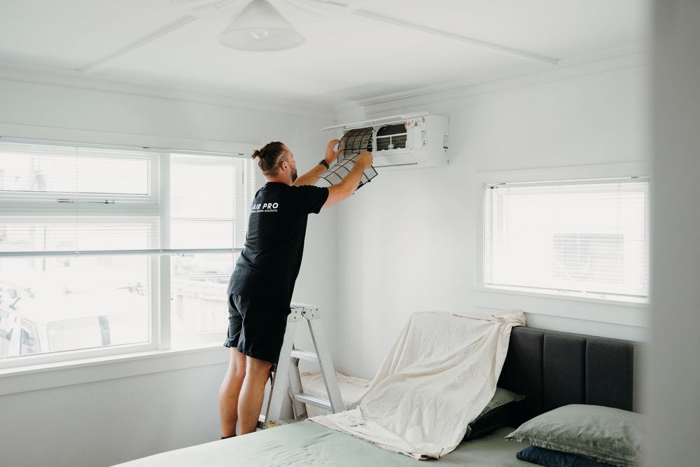 A series of images showing painters covering furniture and walls with plastic sheeting during room preparation.