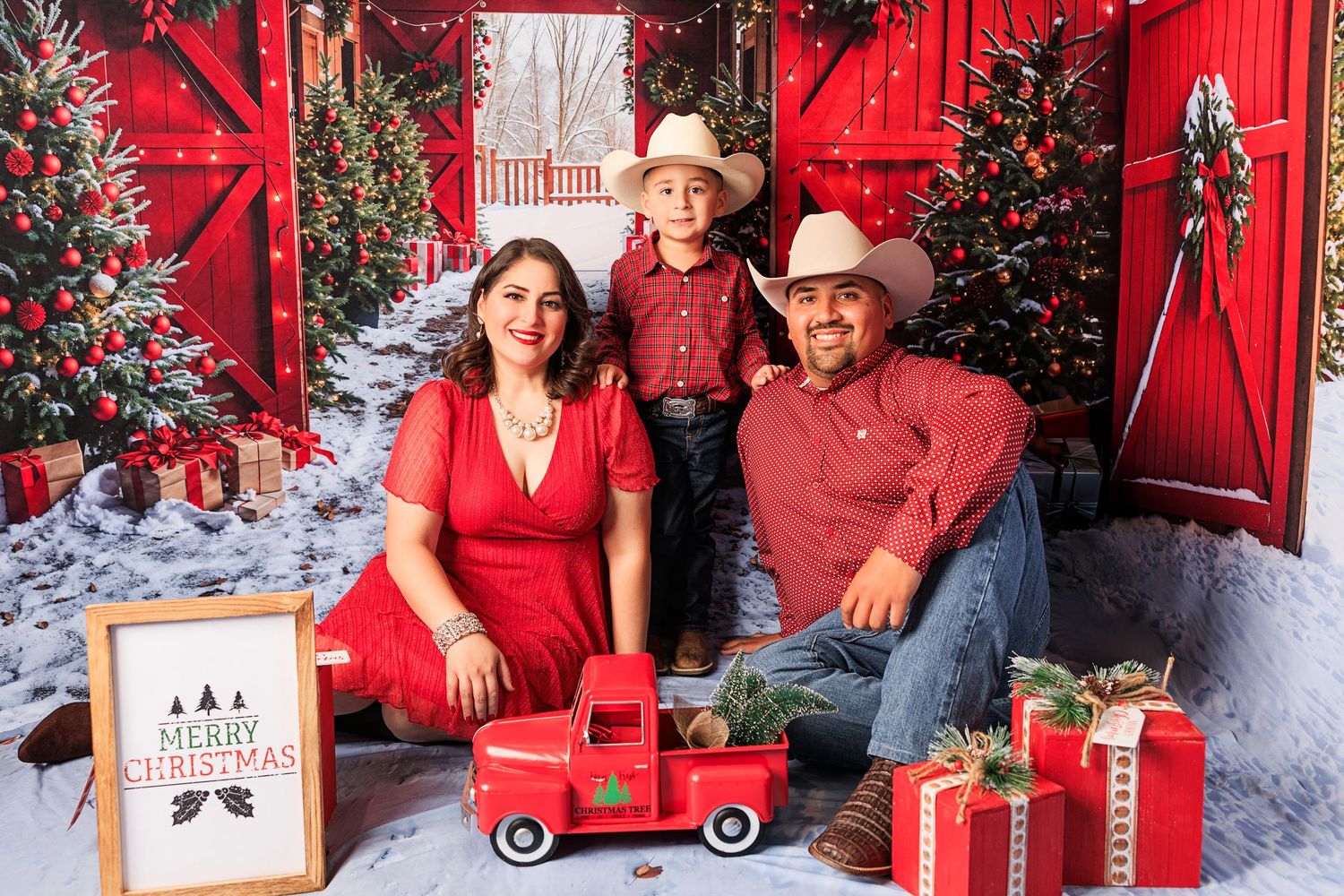 A series of holiday family portraits with a festive red barn backdrop, decorated Christmas trees and rustic winter decor.