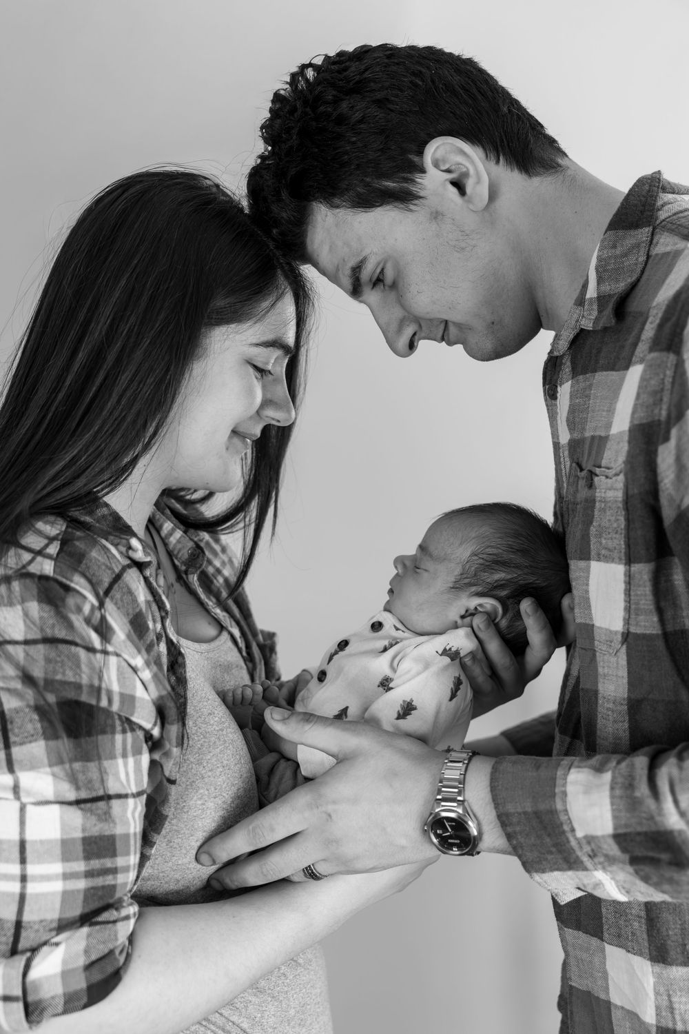 A black and white photo series showing intimate moments between a couple in tender embrace.