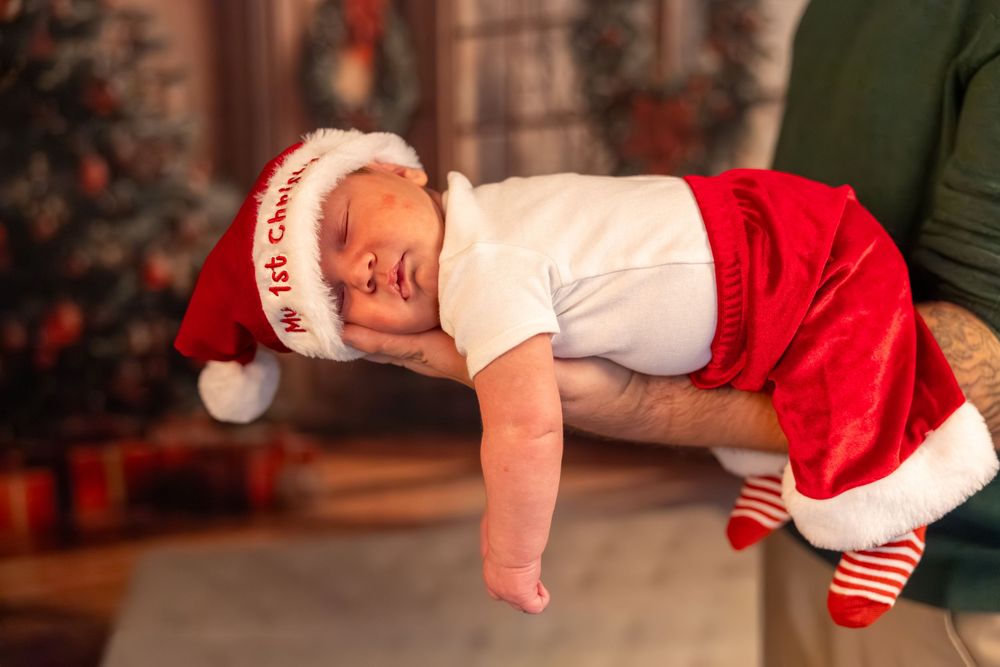 A person in a Santa hat and white shirt performs a breakdancing move on the floor during a holiday celebration.
