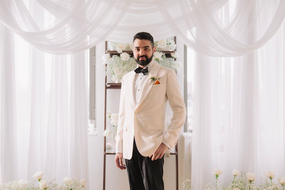 Wedding venue with white draped walls and delicate floral decorations along the floor.