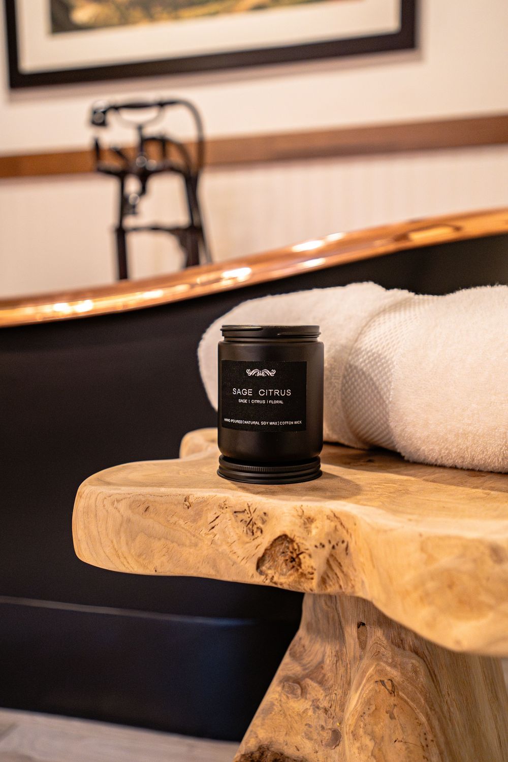 Black cosmetic product container displayed on natural wood live edge surface with white towel.